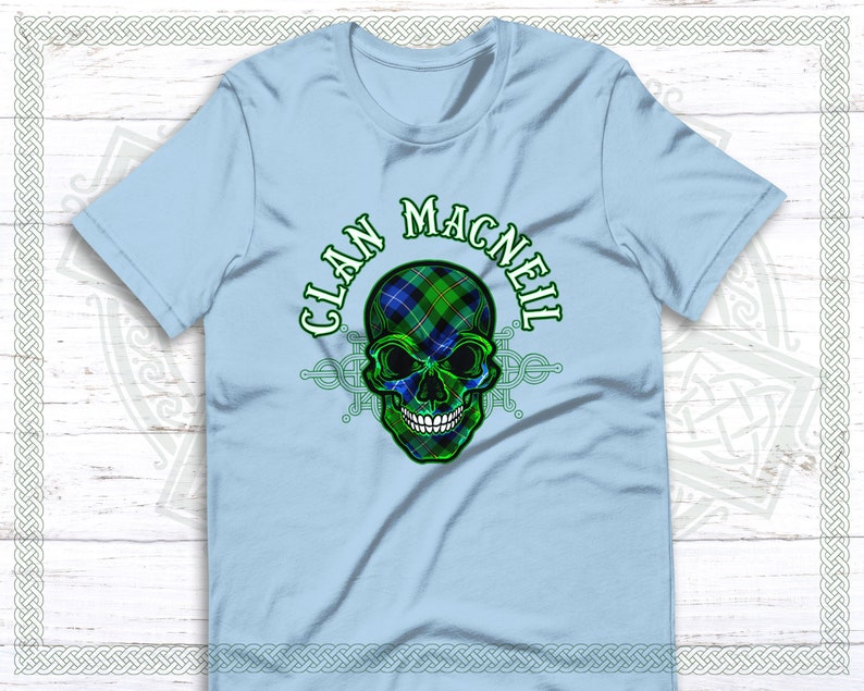 May include: Light blue t-shirt with a green, blue, and black skull design. The skull is wearing a tartan pattern and the text "CLAN MACNEIL" is written around the skull.