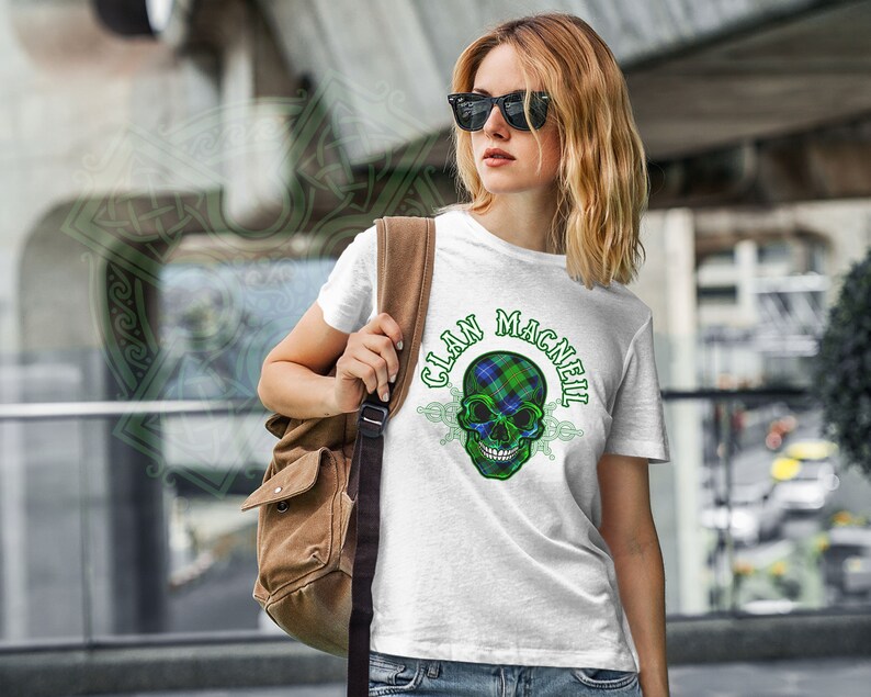 May include: White t-shirt with a green, blue, and white plaid skull graphic and the text "Clan MacNeil".