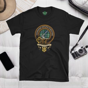 May include: Black t-shirt with a gold crest featuring a green tartan pattern and the text "Courage Helps Fortune" and "Blackadder".