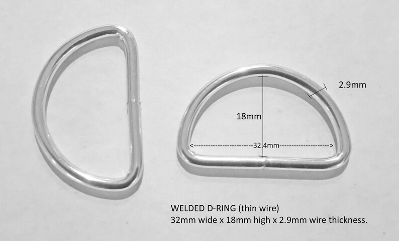 Op de afbeelding: Twee zilveren gelaste D-ringen, elk 32,4 mm breed, 18 mm hoog en 2,9 mm dik.  GELAST D-RING (dunne draad) 32 mm breed x 18 mm hoog x 2,9 mm draaddikte.