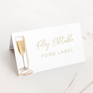 May include: A white food label with gold text that reads "Fully Editable FOOD LABEL". A watercolor illustration of a champagne flute with a pearl necklace is on the left side of the label.