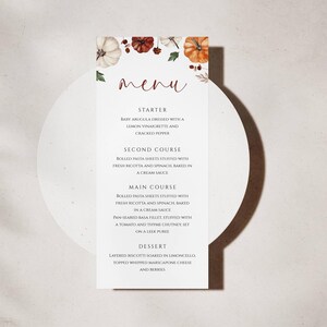 May include: A white menu card with a fall theme, featuring watercolour pumpkins and foliage. The word "menu" is written in a cursive font. The menu lists a starter, second course, main course, and dessert.
