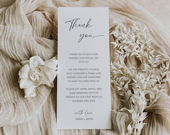 May include: A white thank you card with black text. The card reads "Thank you" in cursive, followed by a message expressing gratitude for attending the wedding and a request to enjoy the celebration. The card is signed "with love, Sarah + Jason".