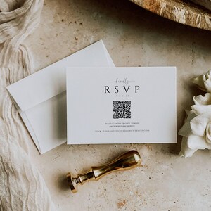 May include: A white RSVP card with a black QR code and the text "kindly RSVP by 2.25 XX" and "PLEASE SCAN THE QR CODE TO RSVP ON OUR WEDDING WEBSITE WWW.THIENOT/OURWEDDINGWEBSITE.COM".