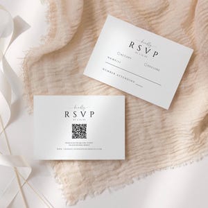 May include: Two white RSVP cards with black text. The top card has a checkbox for accept or decline and a line for the number attending. The bottom card has a QR code and the text "Kindly RSVP by [date]" and "Please scan the QR code to RSVP on our wedding website. www.twoheartsourweddingwebsite.com".