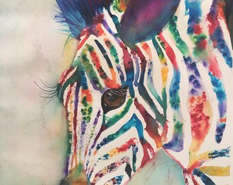 Può includere: Un dipinto ad acquerello della testa di una zebra, con vibranti strisce arcobaleno. Le orecchie e la criniera della zebra sono anch'esse dipinte in uno spettro di colori, su uno sfondo morbido verde chiaro e blu.