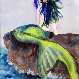 May include: Watercolor painting of a mermaid sitting on a rock. The mermaid has long blue and green hair with a yellow star. Her tail is green and yellow. The background shows blue water and a light purple sky.