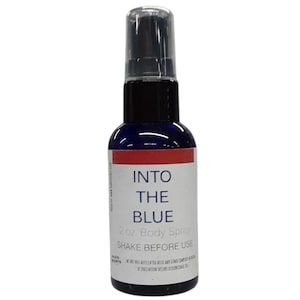 May include: A blue glass body spray bottle with a clear plastic cap. The label reads "Into The Blue" and "2 oz Body Spray". The bottle has a white label with red accents. The text "Shake Before Use" is also visible.