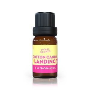 Puede incluir: Una botella de vidrio ámbar de 10 ml de aceite de fragancia con aroma a algodón de azúcar con una tapa negra. La etiqueta es amarilla con texto rosa que dice "PARK SCENTS COTTON CANDY LANDING".