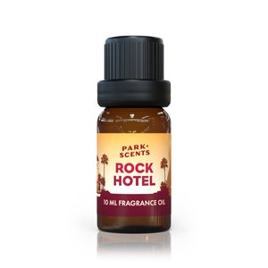 May include: A brown glass bottle with a black cap and a yellow label that says "PARK+SCENTS ROCK HOTEL 10 ML FRAGRANCE OIL".