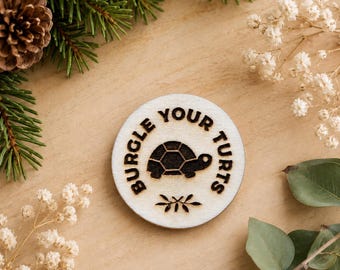 Imán o pin de madera grabado "Más allá del muro del jardín" (Roba tus tortugas)