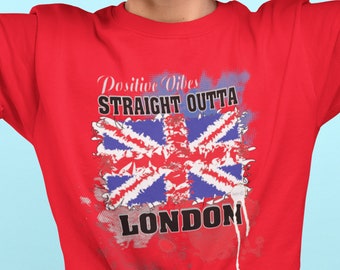 May include: Red t-shirt with a graphic of a British flag and the text "Positive Vibes Straight Outta London". The model is wearing the shirt and holding watermelon slices in front of her eyes.