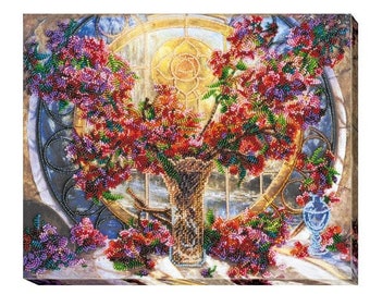 May include: A beaded artwork depicting a bouquet of pink and red flowers in a clear glass vase. The flowers are arranged in front of a stained glass window with a gold frame. The artwork is set against a beige background.