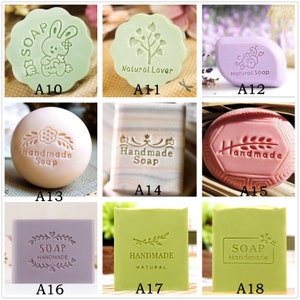 Puede incluir: Nueve sellos de jab&oacute;n diferentes con varios dise&ntilde;os, incluyendo un conejito, un &aacute;rbol, flores y las palabras "Handmade Soap".