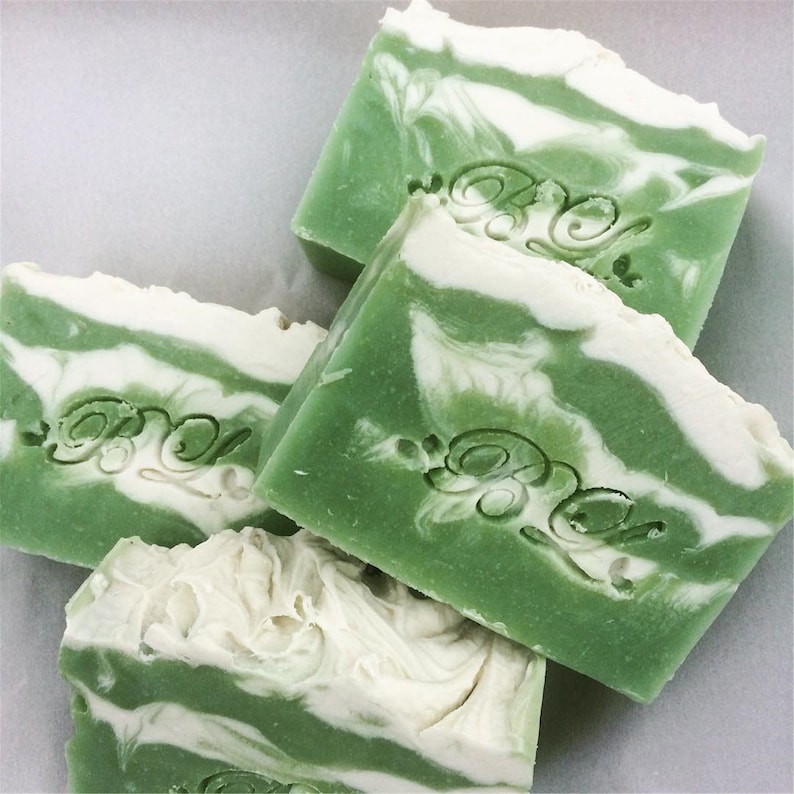 Puede incluir: Cuatro barras de jab&oacute;n de color verde y blanco con la palabra "Grace" grabada en cada barra.