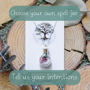 Op de afbeelding: Een zilverkleurige ketting met een kleine, doorzichtige glazen flesjeshanger gevuld met lagen witte, roze en groene kristallen. De hanger wordt gepresenteerd op een witte kaart met een boomlogo en de tekst Bayou Apothecary.