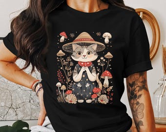 May include: Black t-shirt with a graphic of a cat wearing a mushroom hat and surrounded by mushrooms and flowers.