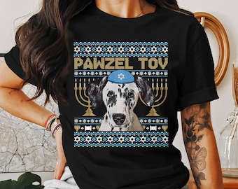 May include: Black t-shirt featuring a Dalmatian dog wearing a blue yarmulke and surrounded by menorahs. The shirt has a festive design with the text "PAWZEL TOV" in gold letters, perfect for Hanukkah celebrations.