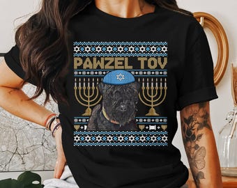 May include: Black t-shirt with a festive design featuring a black dog wearing a blue yarmulke. The design includes the text "PAWZEL TOV", menorahs, and Star of David symbols in gold, blue, and white.