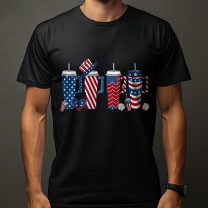 Four festive cups with patriotic patterns and straws on a black t-shirt.