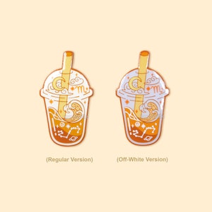 Peut inclure: Deux &eacute;pingles en &eacute;mail repr&eacute;sentant un gobelet de boba tea avec une paille, des nuages, une lune croissante et des &eacute;toiles. L'&eacute;pingle de gauche est une version normale avec une paille jaune et un boba tea orange. L'&eacute;pingle de droite est une version blanc cass&eacute; avec une paille blanche et un boba tea blanc.
