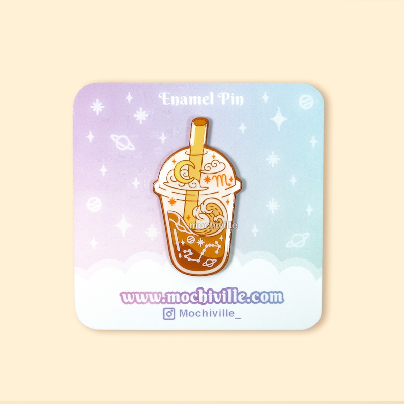 Peut inclure: Une &eacute;pingle en &eacute;mail dor&eacute;e repr&eacute;sentant un gobelet de boba tea avec une paille, une lune, des &eacute;toiles et un motif de vague. Le texte "www.mochiville.com" et "Mochiville_" sont &eacute;galement inclus.