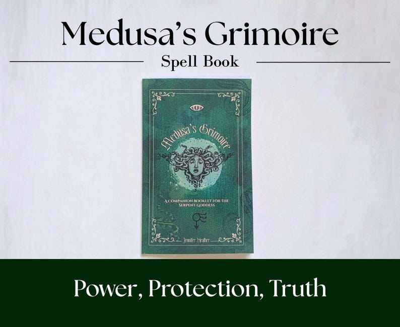 Medusa's grimoire book laying on white background. Cover is green with serpent symbolism.