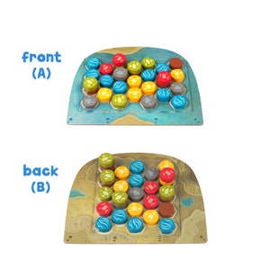 Peut inclure: Un plateau de jeu en bois avec une grille hexagonale. Le plateau a un design oc&eacute;anique bleu et vert et est divis&eacute; en deux sections &eacute;tiquet&eacute;es "avant (A)" et "arri&egrave;re (B)". Le plateau est rempli de pi&egrave;ces de jeu color&eacute;es, notamment rouge, jaune, bleu, vert et marron.