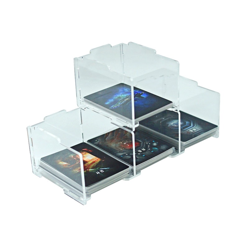 K&ouml;nnte beinhalten: Ein transparenter Kartenhalter aus Acryl mit drei Ebenen zum Aufbewahren und Pr&auml;sentieren von Sammelkarten. Der Halter ist f&uuml;r handels&uuml;bliche Sammelkarten konzipiert und verf&uuml;gt &uuml;ber ein transparentes Design, das es erm&ouml;glicht, die Karten im Inneren zu sehen.