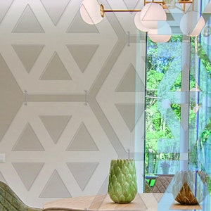 May include: A modern dining room with a large window overlooking a lush green forest. The room features a geometric patterned wall, a wooden table, and two green chairs. A decorative green artichoke-shaped vase sits on the table.