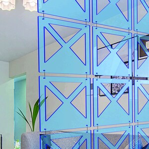 May include: A blue room divider made of acrylic panels with a geometric design. The panels are connected by metal rings.