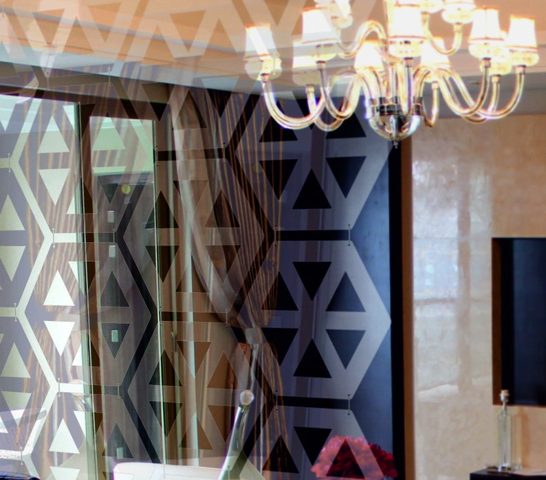 May include: A modern interior design with a large window and a chandelier with crystal accents. The room features a geometric pattern on the wall and a dark wood floor.