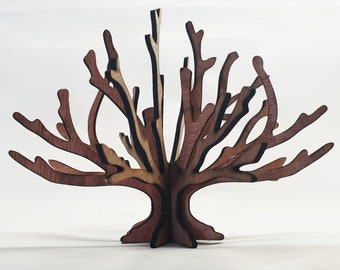 May include: A wooden tree sculpture with intricate branches, crafted from dark brown and light brown wood. The tree has a natural wood finish and stands on a base.