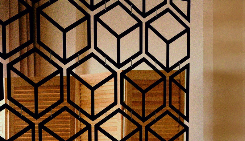May include: A black metal room divider with a geometric pattern of overlapping cubes. The divider is made of thin metal and creates a modern and stylish look.
