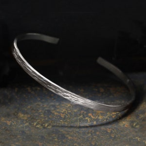 Peut inclure: Un bracelet jonc en argent avec une texture martelée.