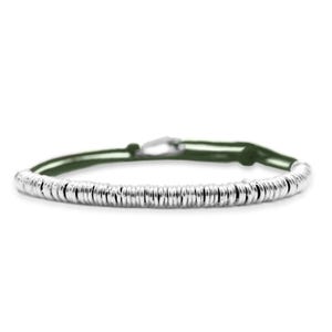 Peut inclure: Un bracelet argenté composé d'une série de petites perles métalliques rondes enfilées. Le bracelet est doté d'un cordon vert et d'un fermoir argenté. Le bracelet est présenté sur fond blanc.