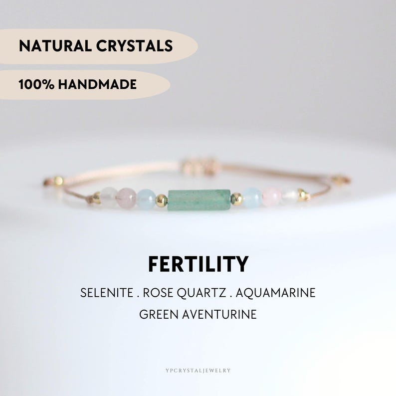 May include: A handmade bracelet featuring selenite, rose quartz, aquamarine, and green aventurine beads. The bracelet has a beige cord and gold-colored accents. The text "NATURAL CRYSTALS" and "100% HANDMADE" are displayed above the bracelet. The word "FERTILITY" is also displayed.