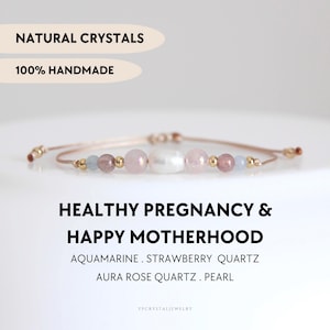 May include: A beaded bracelet featuring a central white pearl flanked by pink rose quartz, strawberry quartz, and light blue aquamarine beads, accented with small gold-tone metal spheres on a thin cord. Text reads: NATURAL CRYSTALS 100% HANDMADE HEALTHY PREGNANCY & HAPPY MOTHERHOOD AQUAMARINE . STRAWBERRY QUARTZ AURA ROSE QUARTZ . PEARL YPCRYSTALJEWELRY