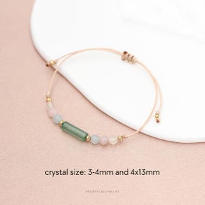 May include: A delicate bracelet featuring a combination of pink, green, and clear beads. The bracelet includes a central green rectangular crystal, pink and clear round beads, and gold-colored accents. The text on the image reads "crystal size: 3-4mm and 4x13mm".