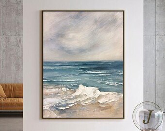 May include: Abstract painting of a seascape with white foamy waves crashing on a sandy beach. The sky is a soft blue and white with a hint of pink. The painting is framed in a simple brown frame.