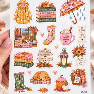 May include: A sticker sheet titled AUTUMN SOUL RAINY DAY featuring illustrations of a yellow raincoat, stacked books, a floral umbrella, a cat by a window, patterned socks, a mug, a lantern, a dog, pumpkins, and a basket with the text AUTUMN GOODNESS.