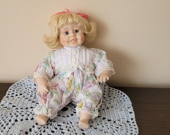 Vintage porcelain sitting doll with open mouth