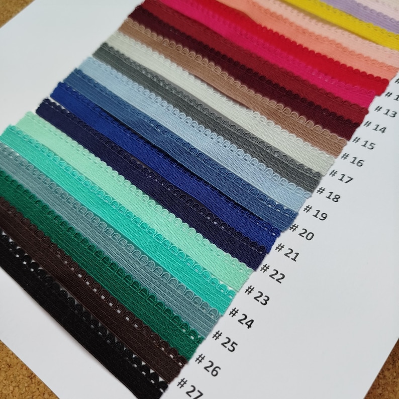 May include: A variety of colors of elastic trim with scalloped edges. The trim is numbered 1 through 27.