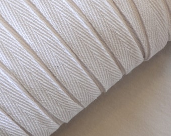 May include: White cotton twill tape with a herringbone pattern. The tape is rolled up and the edges are visible.