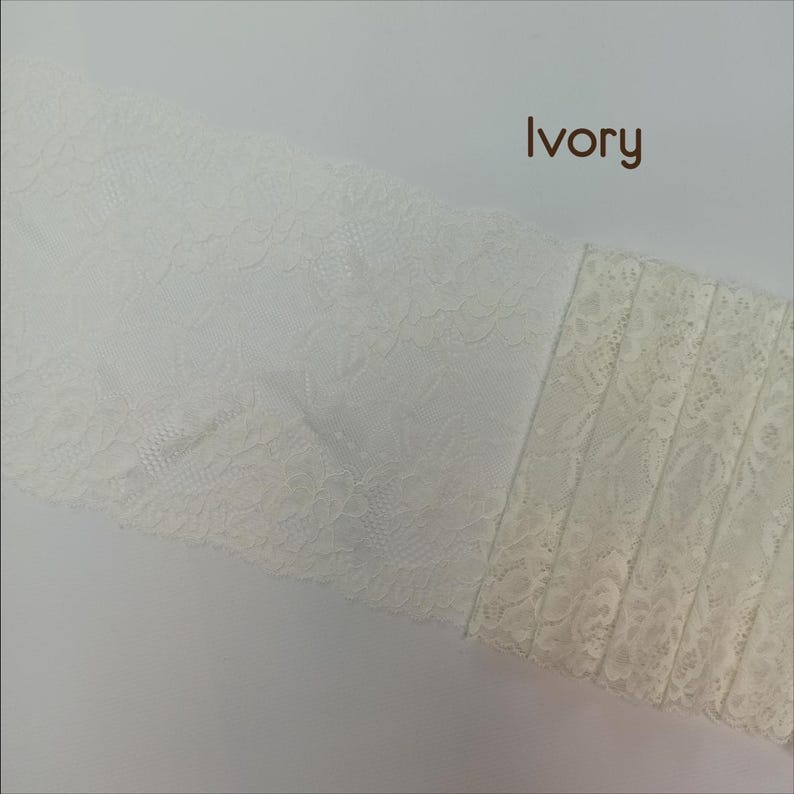 May include: Two pieces of ivory lace fabric. One piece has a delicate floral pattern, while the other has a more intricate design with vertical lines.