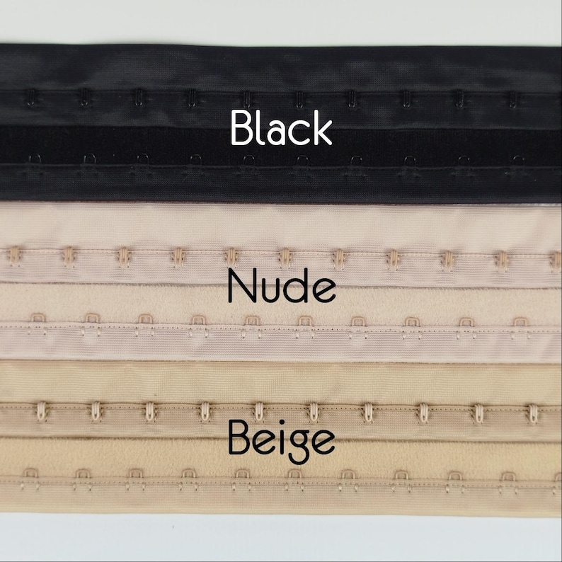 May include: A close-up image showing three rows of bra hook and eye closures in black, nude, and beige. The word "Black" is above the black row, "Nude" above the nude row, and "Beige" above the beige row. The closures are made of metal and fabric.
