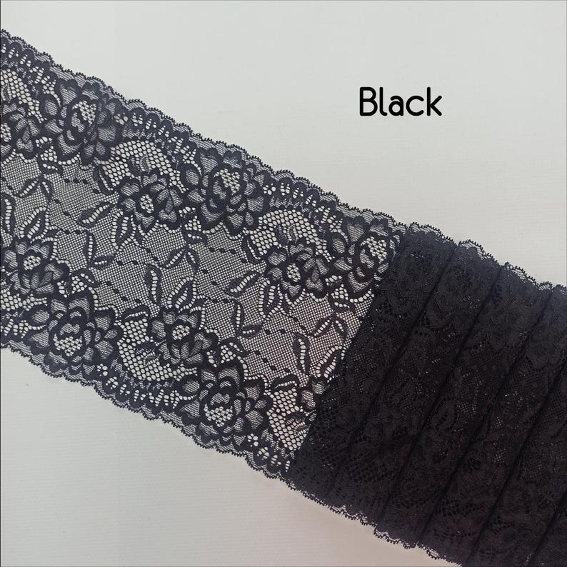May include: Black lace trim with a floral pattern. The lace is delicate and has a soft, flowing texture.