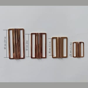 May include: Four gold-toned metal clasps of different sizes. The clasps are 60 mm (2.4 in), 50 mm (2 in), 40 mm (1.5 in), and 30 mm (1.2 in) in length.