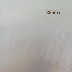 May include: White lace trim with a delicate floral pattern. The lace is soft and flexible, making it ideal for adding a touch of elegance to any project.