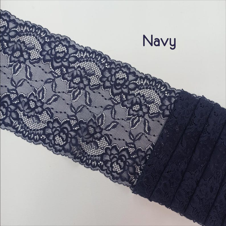 May include: Navy blue lace trim with a floral pattern. The lace is delicate and intricate, with a soft, flowing texture.